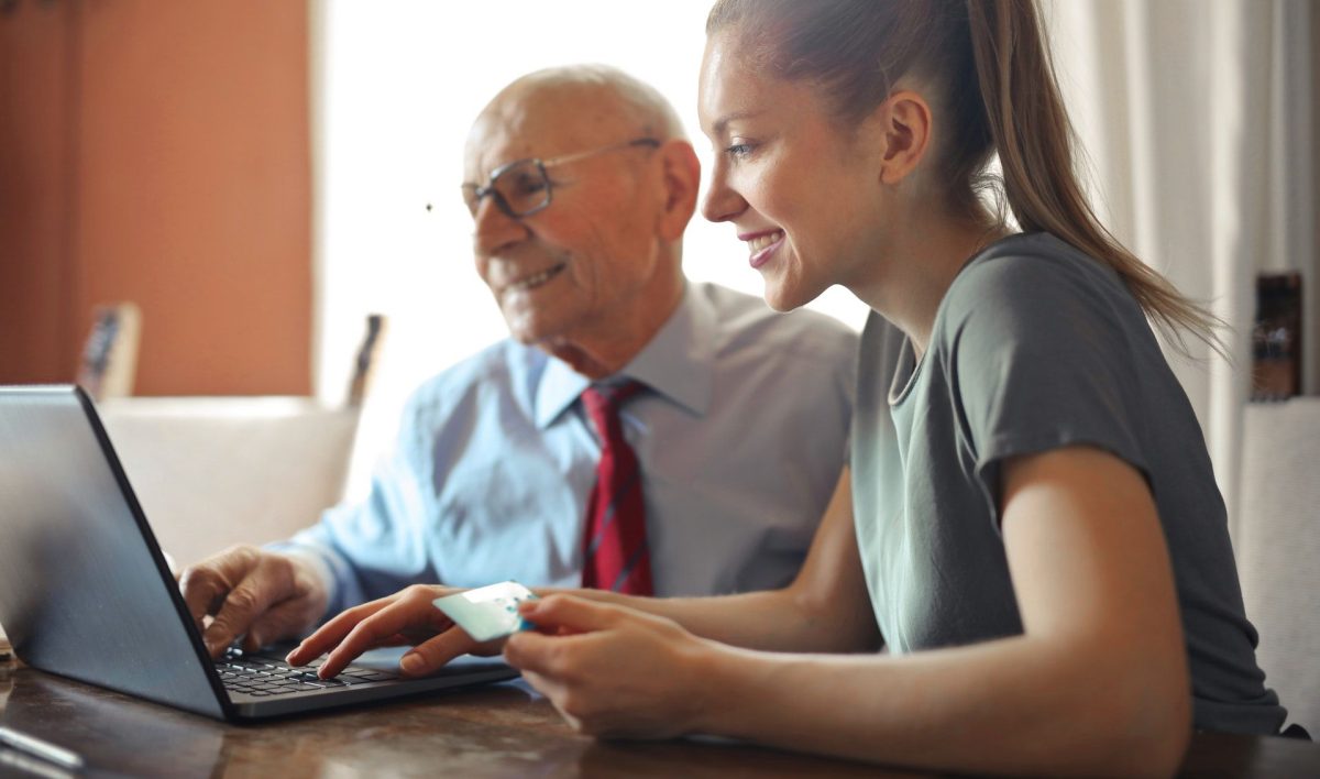 Senior gibt Azubi nachhilfe am Computer