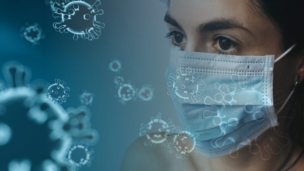 Frau mit Mundschutz zwischen Viren