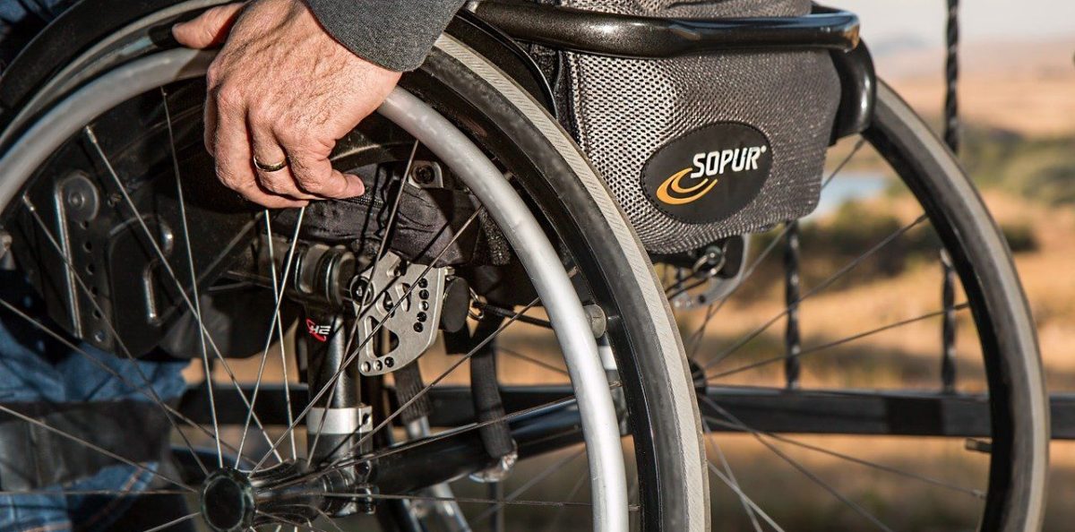 Rollstuhlfahrer fährt, mit Fokus auf die Räder